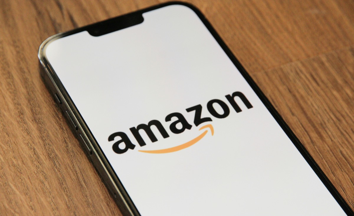 A smartphone on a wooden desk displaying a shopping app.